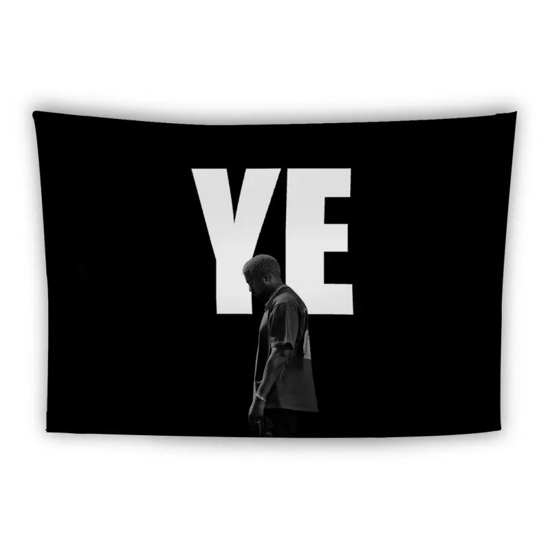 A person stands facing downward in front of a black background with large, bold white letters "YE" displayed prominently above their head. The individual is dressed in dark clothing and appears to be deep in thought or contemplation.