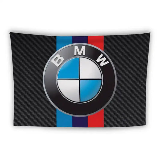 A large BMW logo against a background featuring a black carbon fiber texture. Behind the logo, there are three vertical stripes in blue, purple, and red from left to right, echoing the iconic BMW motorsport colors.