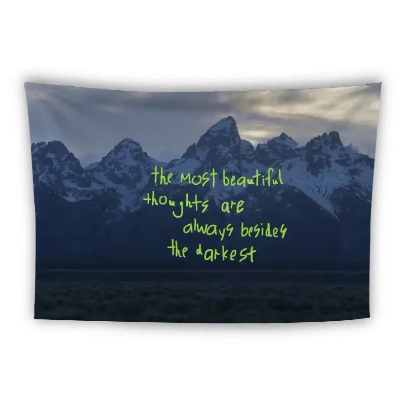 A tapestry displaying a mountain range during twilight. Snow-capped peaks contrast with a dark foreground. Overlaid text reads, "the most beautiful thoughts are always besides the darkest" in neon green font.