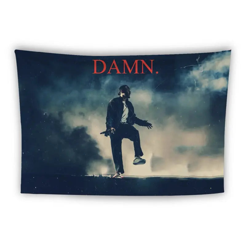 A dark figure stands on one leg in a dramatic, smoky scene with "DAMN." written in bold red letters at the top. The background features a moody, cloudy sky, creating a mysterious and intense atmosphere.