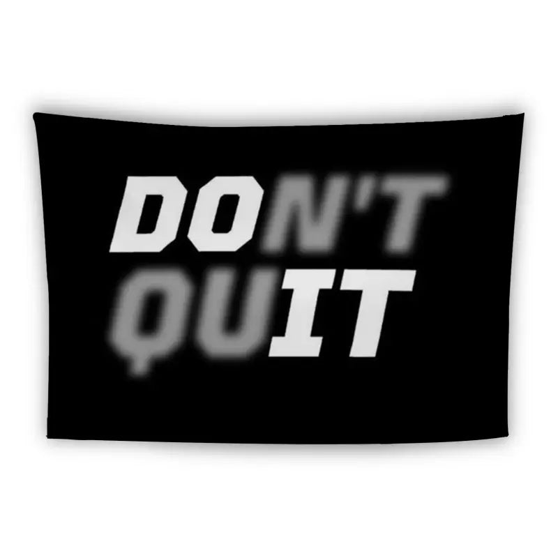 A black rectangular banner with white text reading "DON'T QUIT." The word "DON'T" is clear, while "QUIT" is partially blurred, creating an impression of motion.