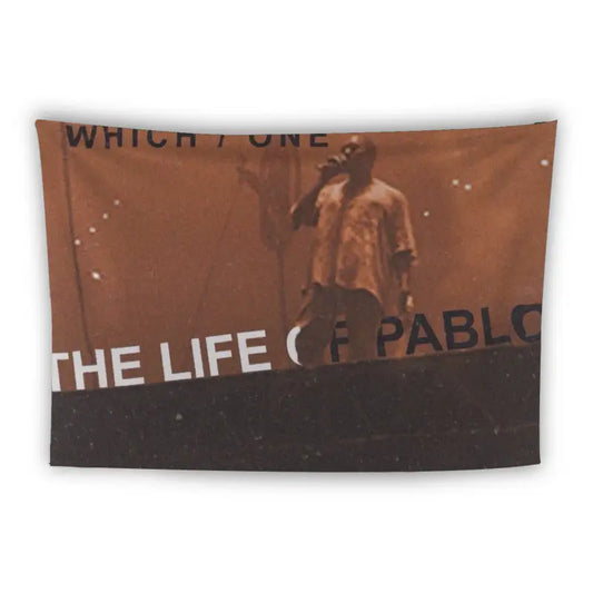 A tapestry features a photo of a performer wearing a light-colored shirt, singing passionately on a dimly lit stage. Text overlay reads "THE LIFE OF PABLO" at the bottom, partially obscured, and "WHICH / ONE" at the top left.