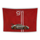 A red tapestry features an image of a white Porsche 911 sports car with red rims and a raised rear spoiler. Above, the text "Porsche 911" is written in white, with two vertical white stripes extending from the top to the car.