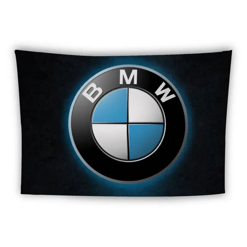 A black rectangular banner displaying the BMW logo in the center. The logo consists of a circular emblem divided into four quadrants, alternating between blue and white colors, with the letters "B M W" around the top half of the circle.