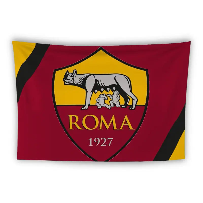 A flag features the emblem of the AS Roma football club. The emblem includes a depiction of the mythological she-wolf suckling the twins Romulus and Remus, set against a yellow background on the upper half and a red background on the lower half. The word "ROMA" and the year "1927" are written below the image. The flag has black diagonal stripes on both the top left and bottom right corners.