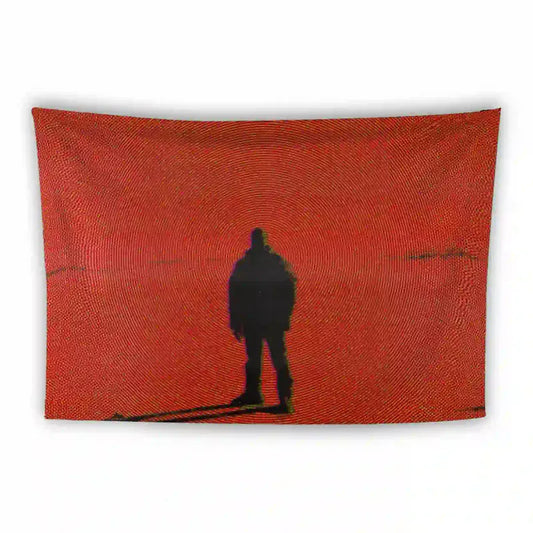 A rectangular tapestry with a red background features the black silhouette of a person standing and facing forward. The red backdrop has circular patterns radiating outward from the figure, creating a hypnotic effect.