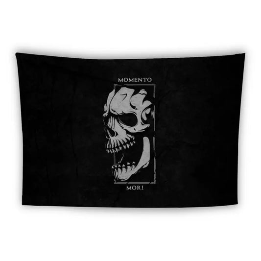 A black rectangular tapestry features a white, stylized skull on the right side, partially enclosed in a rectangular frame with intricate detailing. Above the skull, the text reads "MOMENTO MORI" in capital letters.