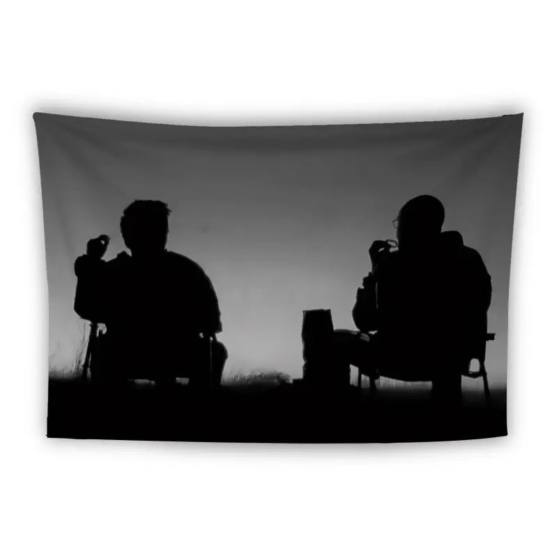 Silhouettes of two people sit facing each other, raising cups in their hands, suggesting a relaxed outdoor setting. They appear to be seated on chairs with a table or object between them, against a gradient background from gray to white.