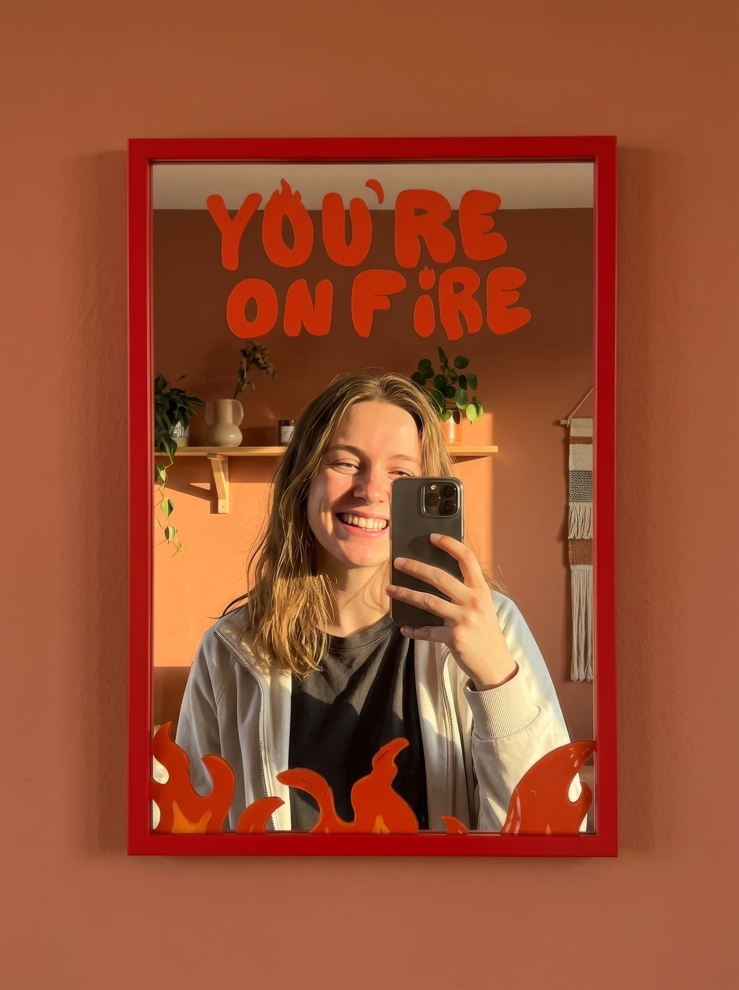 Red wood-framed wall mirror with You're On Fire text and orange painted flame graphics at the base