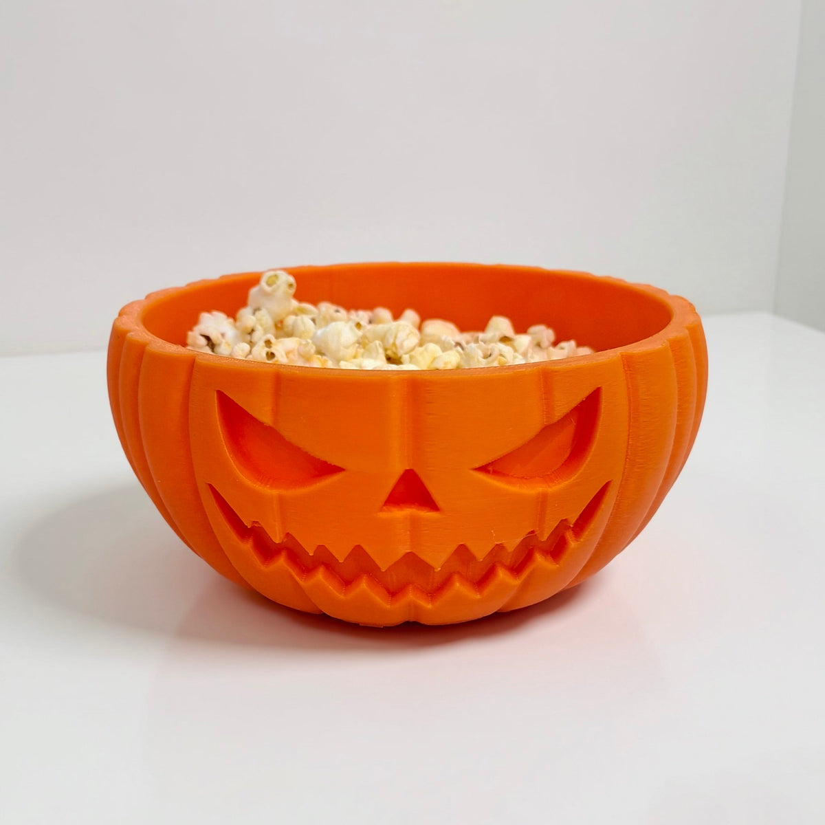 Jack-o'-lantern pumpkin bowl filled with popcorn
